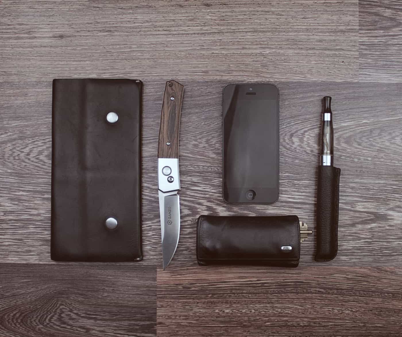 Everyday carry items including a knife and wallet laid out flat