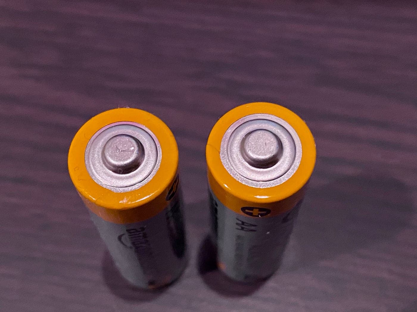 A row of batteries arranged on a dark surface
