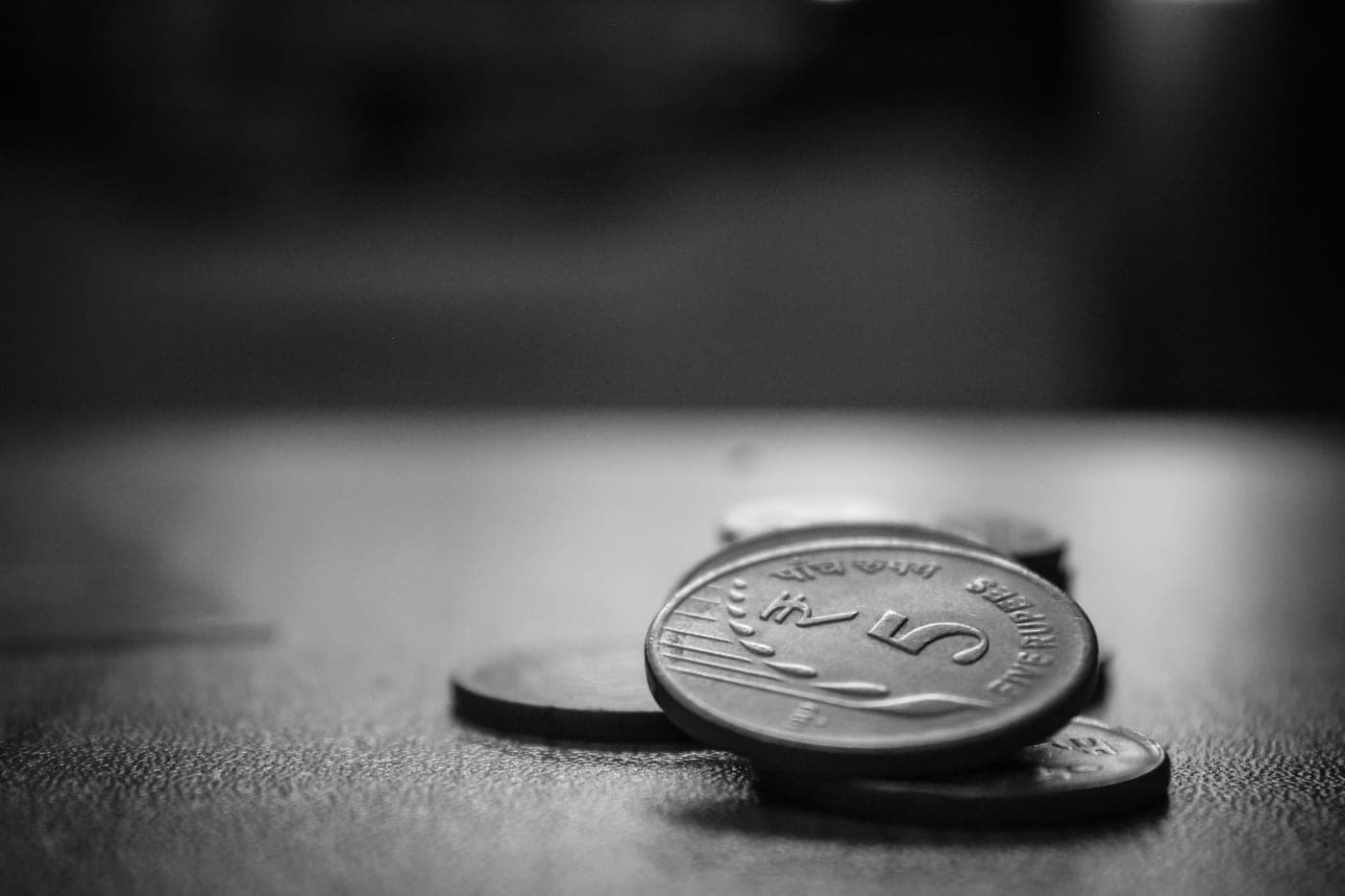 A flashlight and loose coins arranged on a dark table