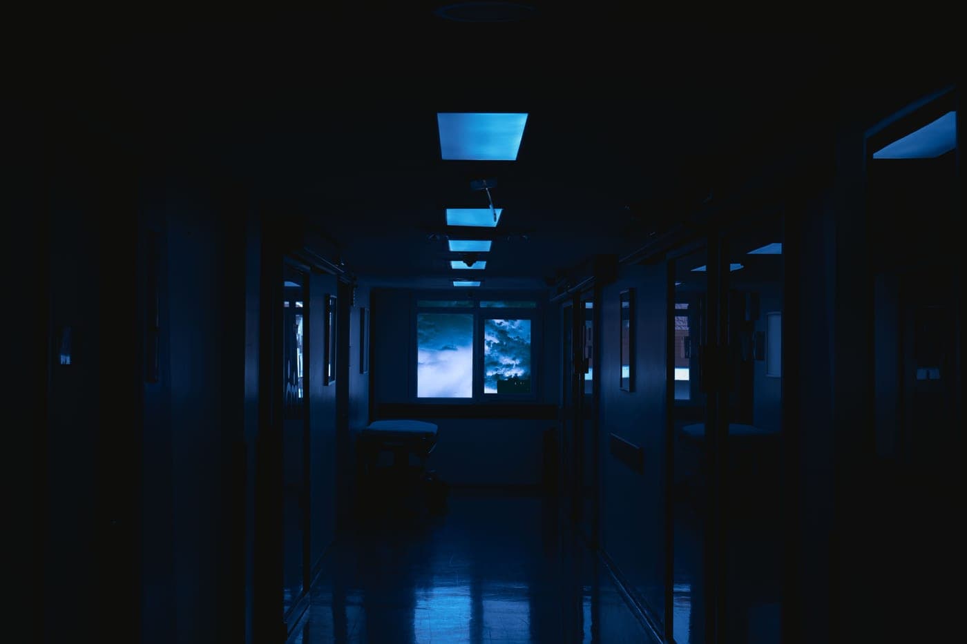 A dark corridor in a house lit from a doorway