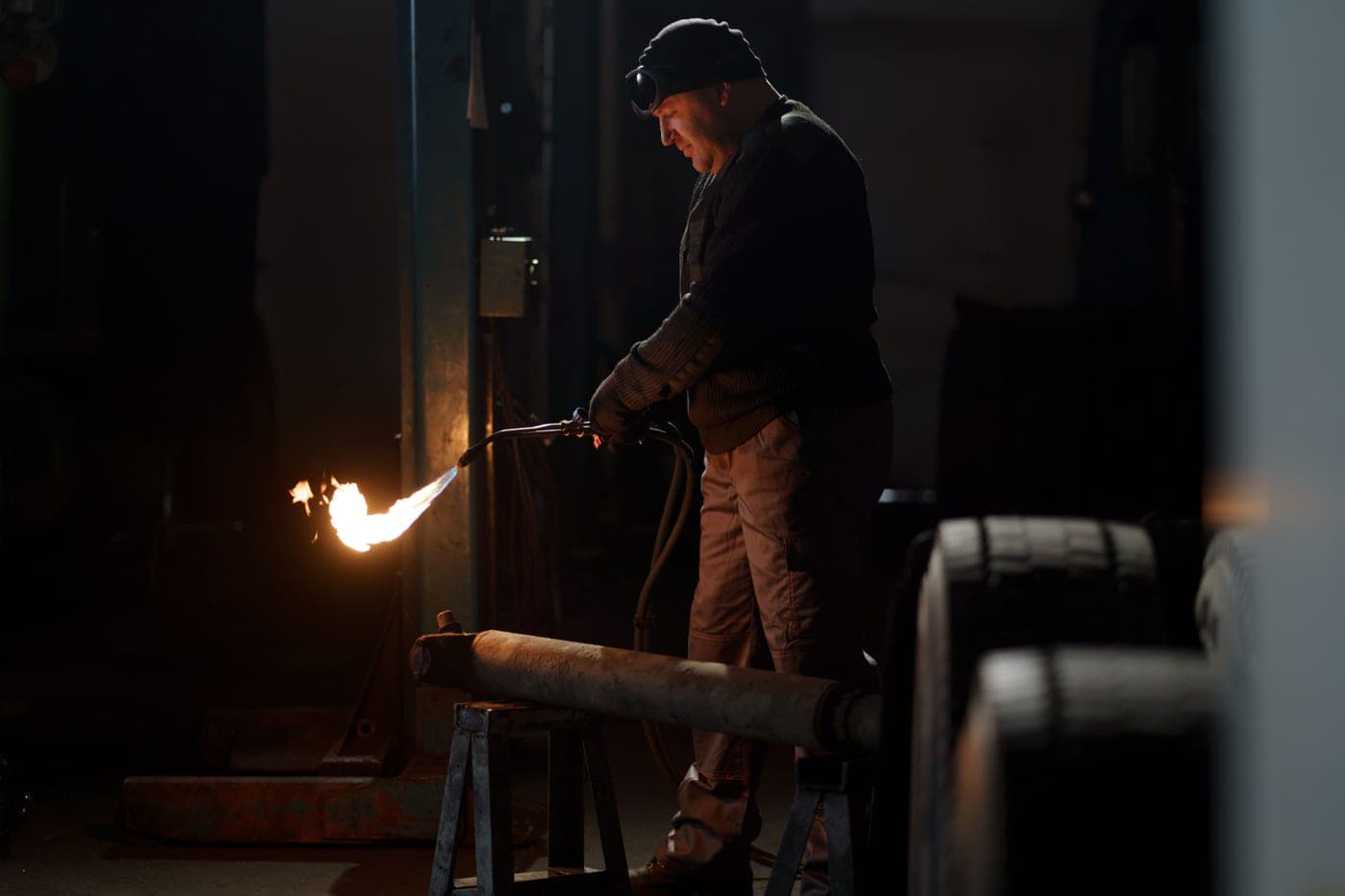 A long metal torch resting on a wooden surface