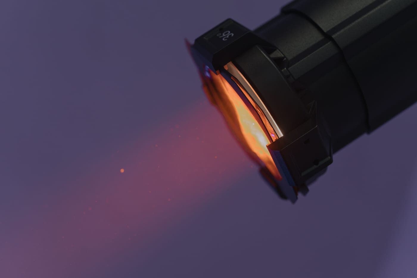 A close-up of a flashlight projecting warm light in the dark