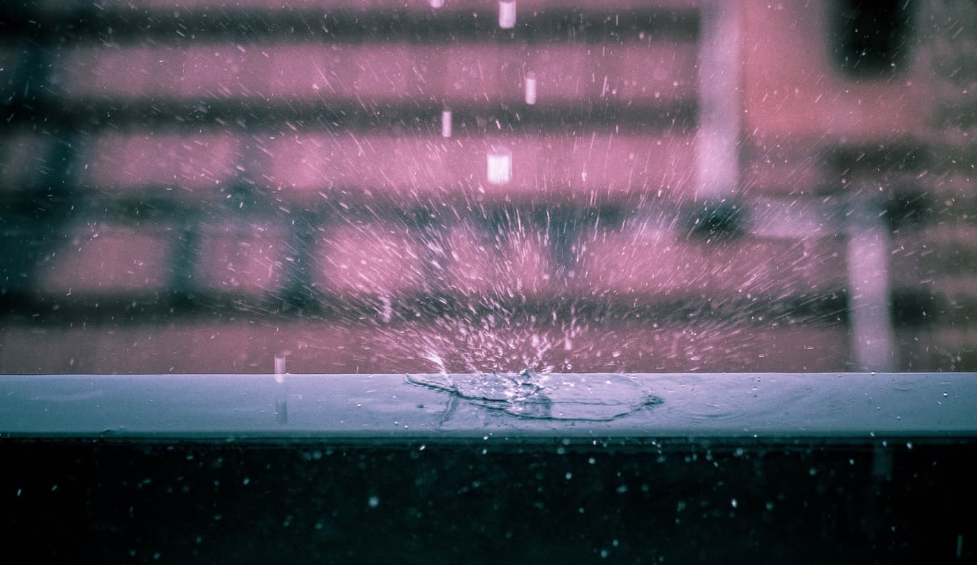 A rain droplet splashing on a dark surface