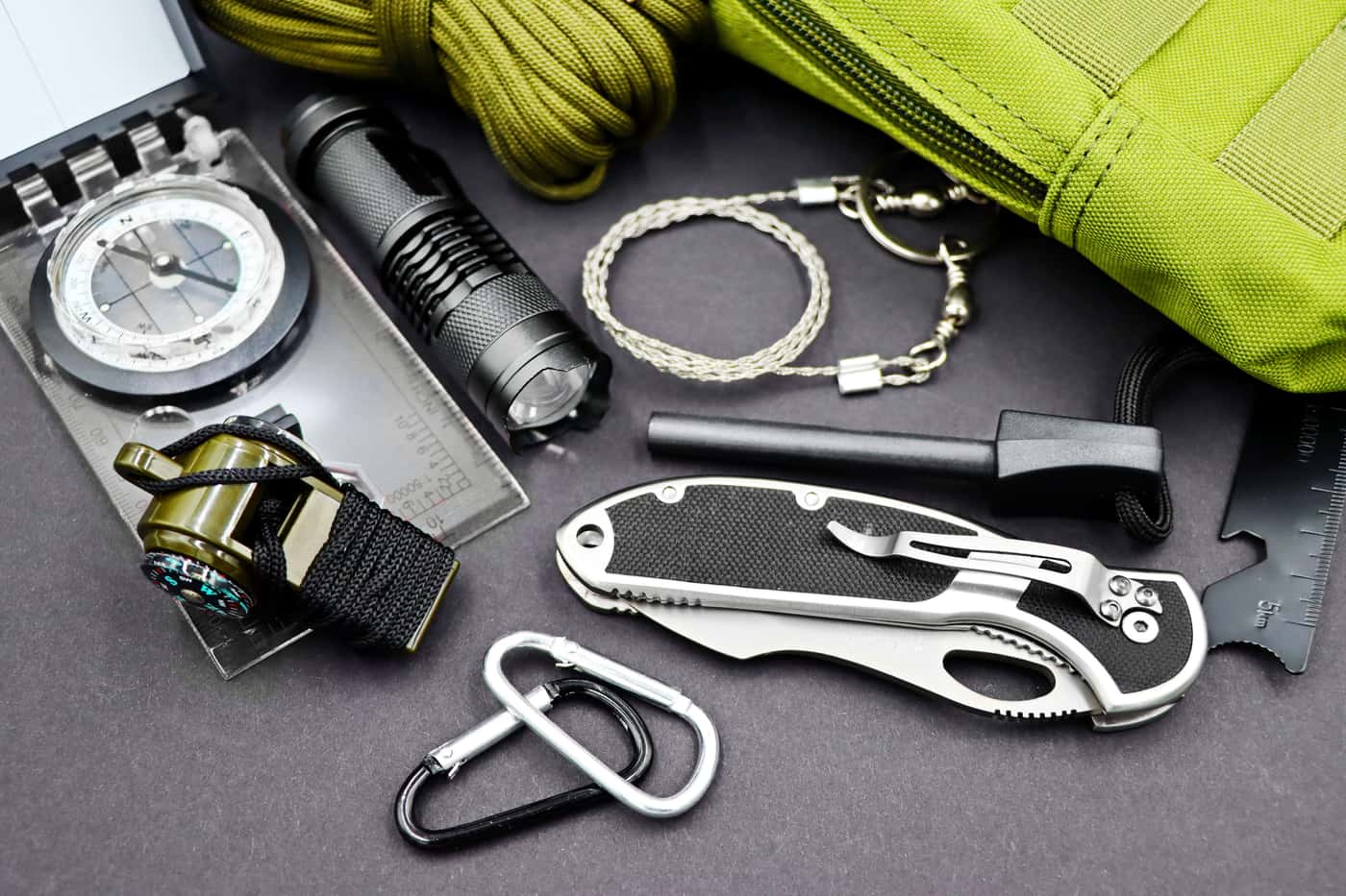 A layout of survival tools including a compass, flashlight and knife