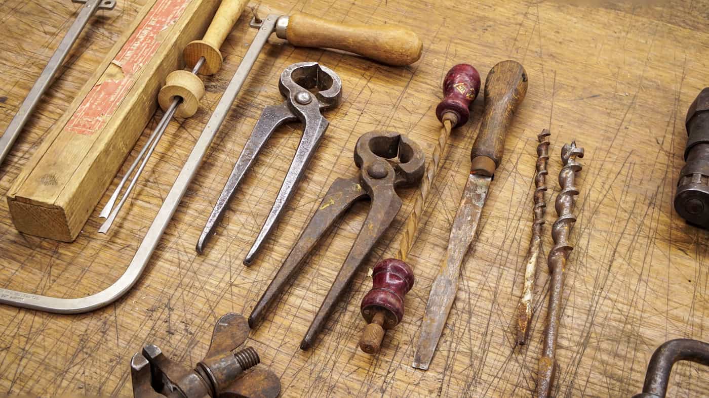 Inexpensive hand tools resting on a wooden bench