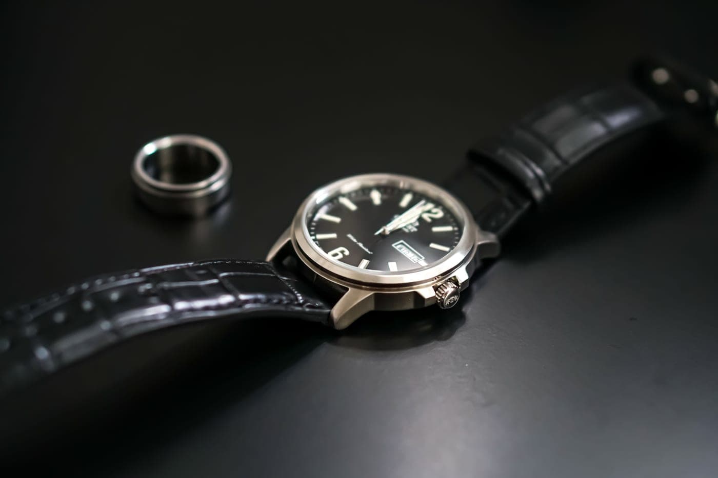 A classic wristwatch photographed from above on a dark surface