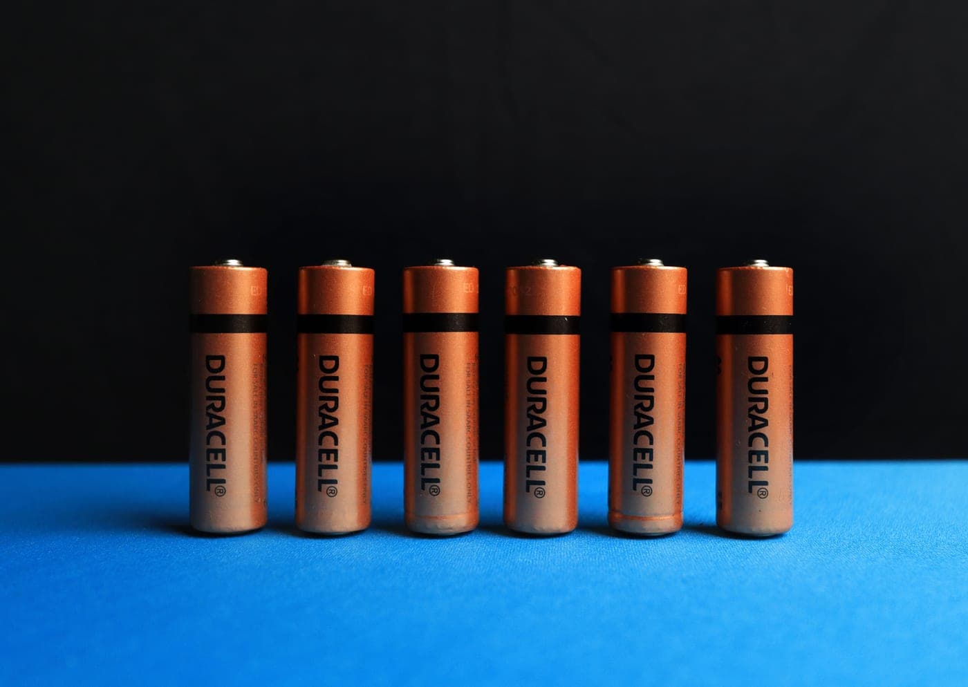 A row of alkaline batteries laid out on a surface