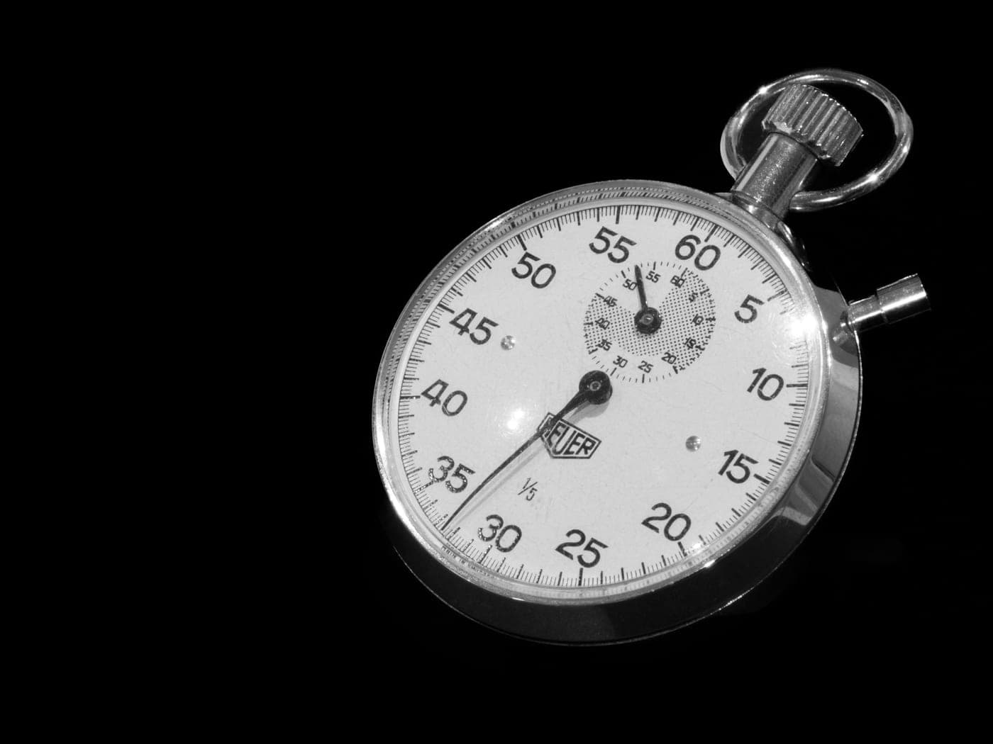 A mechanical stopwatch on a dark surface
