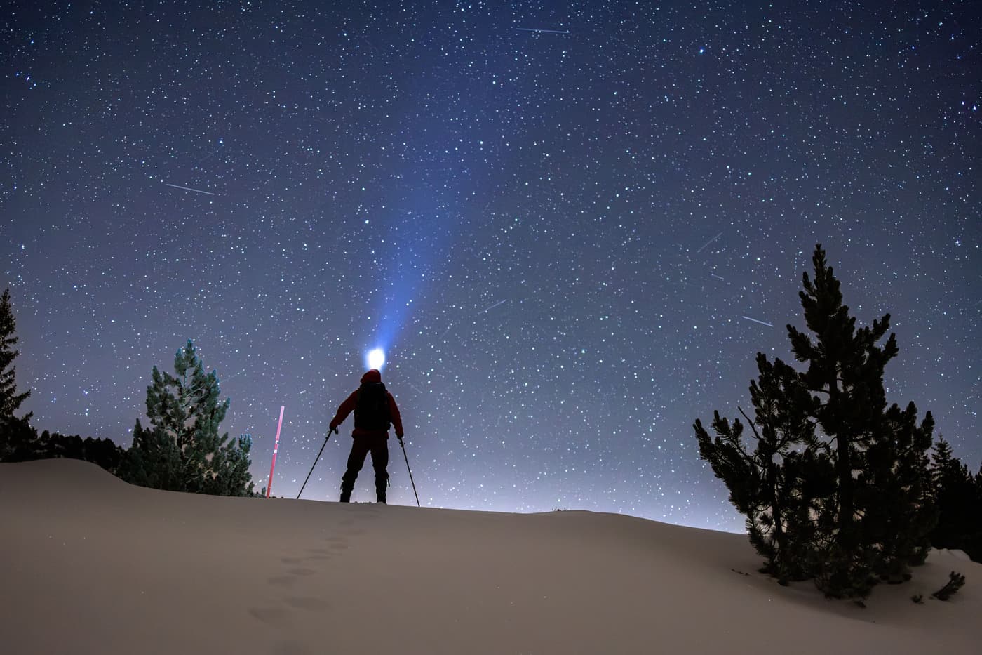 A nighttime skiing scene under a starlit sky