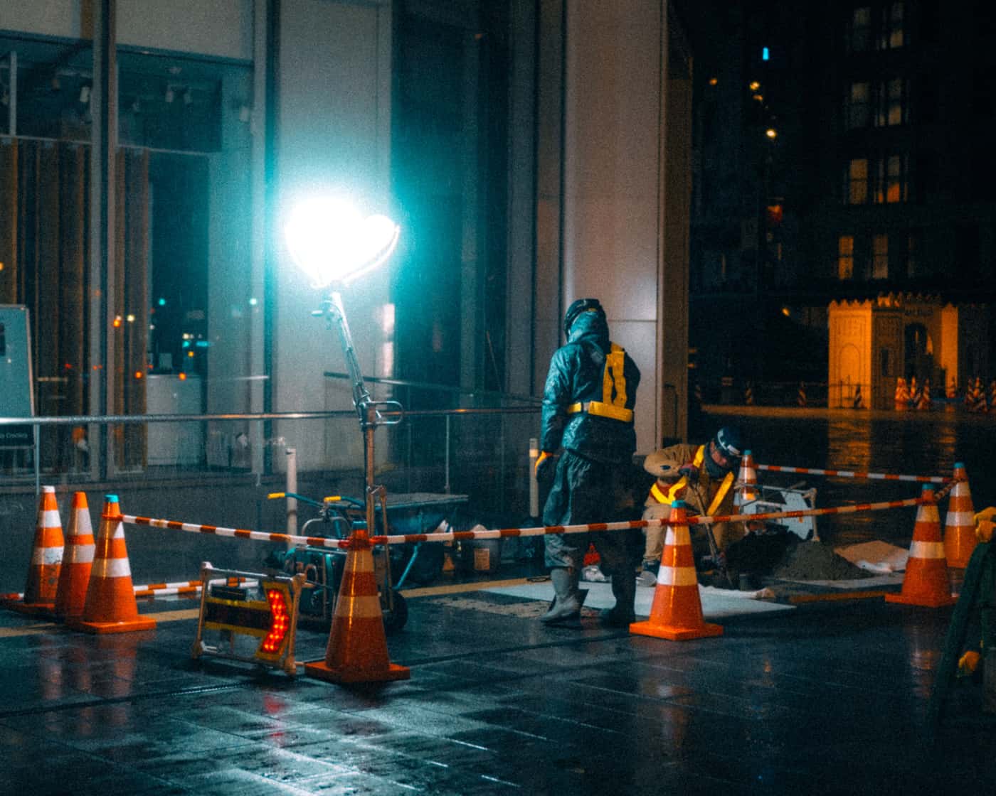 A worker on a construction site at night lit by a head torch
