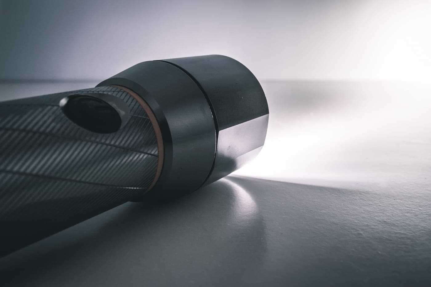 A handheld flashlight lying on a worn wooden table