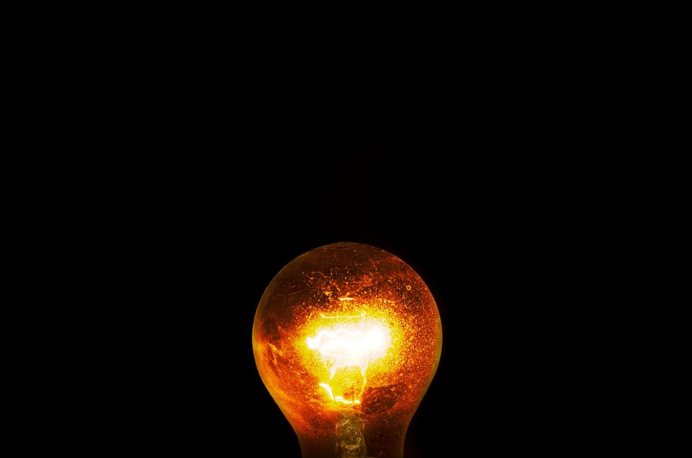 A single light bulb glowing against a dark background