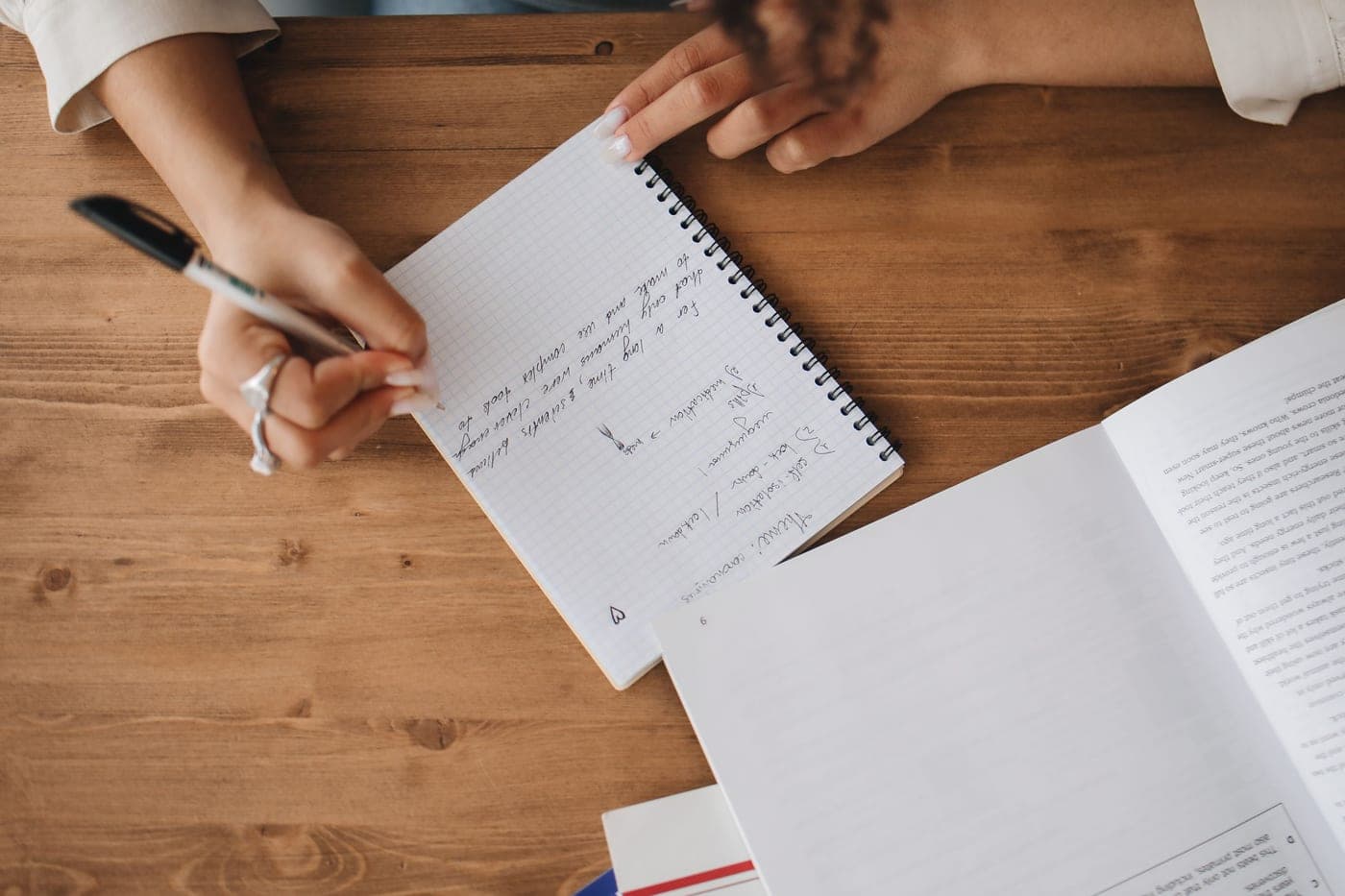An open product manual and handwritten notes on a dark desk
