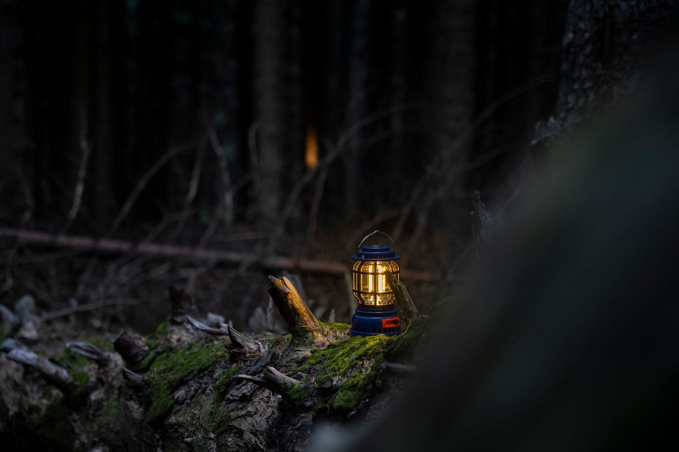 A camping lantern glowing warmly in the dark