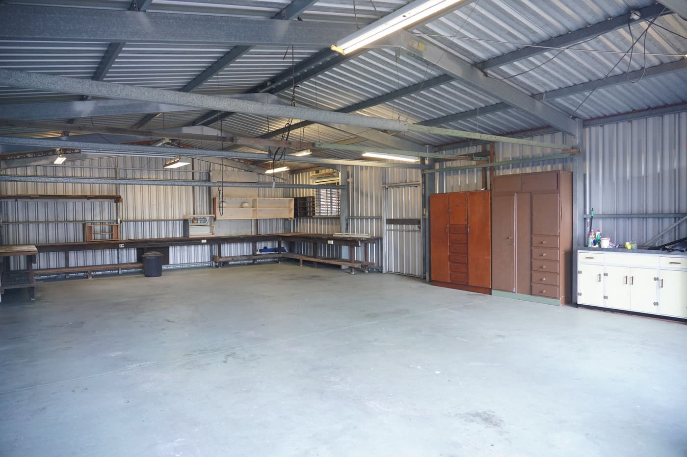 An empty garage workshop with cabinets and a workbench
