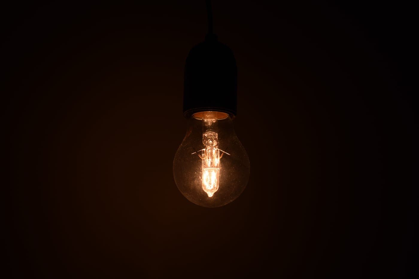 A single bulb glowing warmly in an otherwise dark room